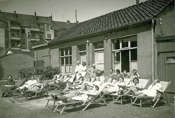 Hier sieht man ein Bild aus den Gründerzeiten der Repha mit Mitarbeitern in der Mittagspause auf Liegestühlen